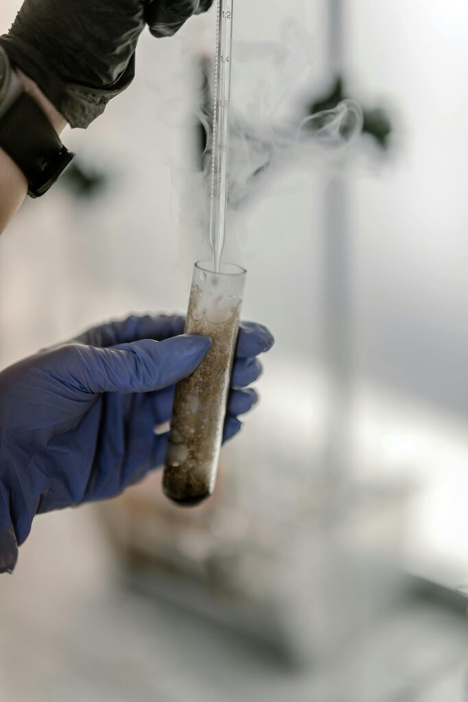 Close-up of a scientist's hands conducting an experiment with smoke in a laboratory setting.